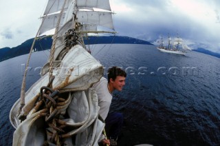 Crew member sitting on the bowsprit of tall ship Sorlandet