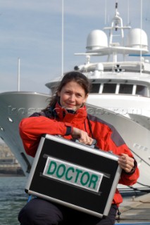 Female Doctor with medical kit in front of superyacht