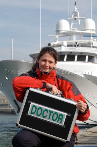 Female Doctor with medical kit in front of superyacht                                 
