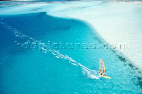 Aerial view of windsurfer speeding over calm clear sea