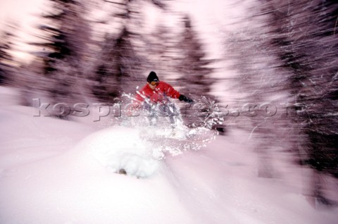 Snowboarder jumps through powder snow