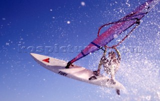 Close up of windsurfer jumping off wave