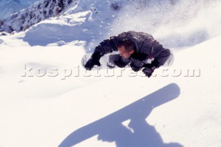 Snowboarder and his shadow mid air.