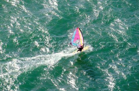 Aerial view of windsurfer speeding across flat water