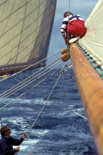 Crew member on main sail boom of classic yacht Adix