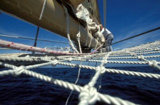 Crew member on bow sprit of classic yacht Adix
