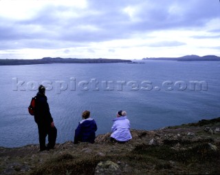 Three people enjoying the view from St Davids Head, Pembrokeshire, Wales