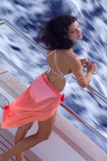 Woman in bikini relaxing on superyacht