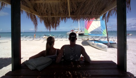 Two people under the shade of a beach hut Caribbean