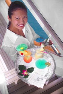 Superyacht stewardess with tray of cocktails
