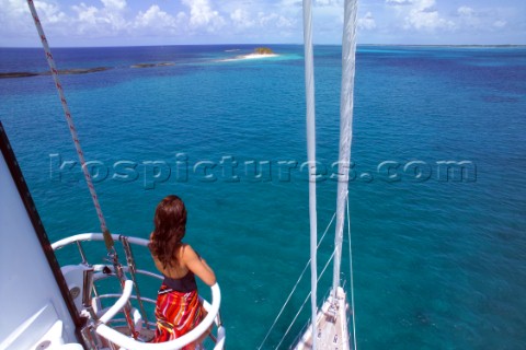 Woman looking out to sea from crows nest on superyacht