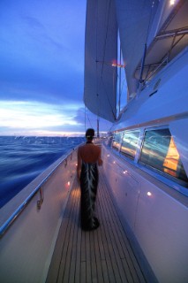 Woman in evening dress on side deck of superyacht