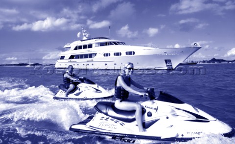 Jet skiers driving passed anchored superyacht