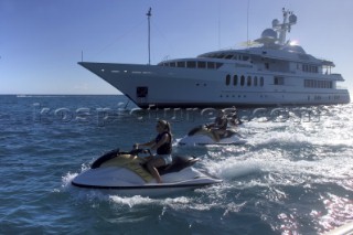 Jet skiers riding passed anchored superyacht