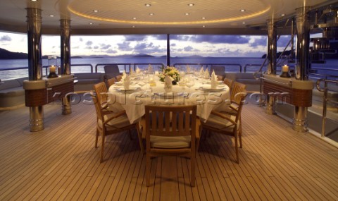 Table laid for dinner on aft deck of superyacht