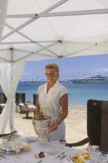 Superyacht stewardess prepares lunch for guests on Caribbean beach