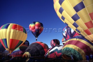 Hot air balloons rising into blue sky
