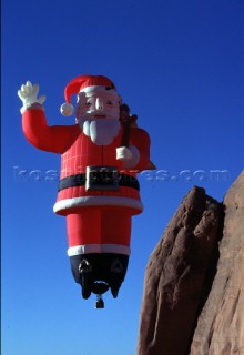 Santa Claus hot air balloon rising into blue sky