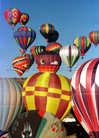 Hot air balloons rising into blue sky