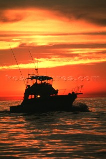 Game fishing boat at sunset.
