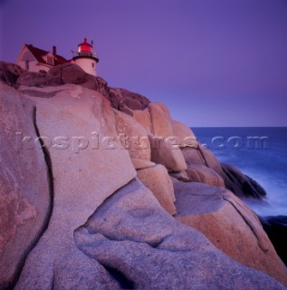 Lighthouse perched on top of rock cliff