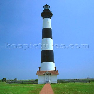 Black and white lighthouse on green grass