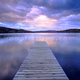 Wooden jetty on lake at sunset