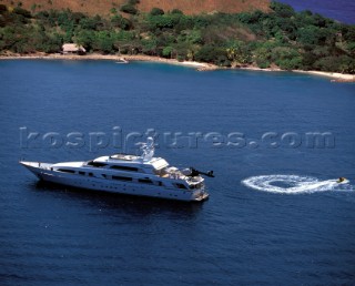 Superyacht at anchor in a tranquille bay with recreational jet ski water bike