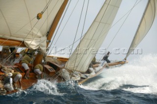 Wave crashing over bow of classic yacht