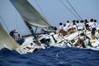 Crew on racing yacht in rough seas.