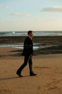 Male model walking on beach in casual wear