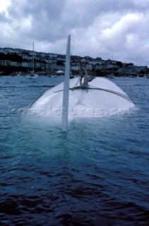 The Maxi yacht Drum owned by Simon Le Bon of Duran Duran lies upturned and capsized without its keel in Falmouth Harbour after the accident of the Fast race in 1985