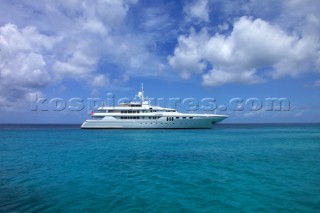 Superyacht at anchor in clear blue Caribbean sea.