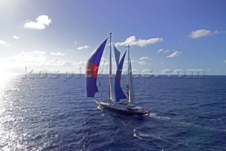 Ketch superyacht sailing down wind under spinnaker