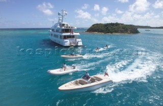 Tenders and jet skis driving behind the stern of luxury superyacht Huntress