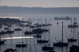 Fishing boat leaving through yacht moorings on a tranquille evening in Falmouth Harbour UK