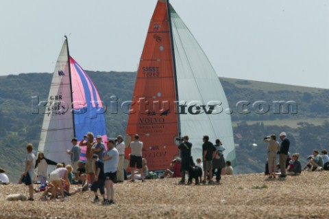 The Fasntet fleet pass through the Solent by Hurst Castle watched by a crowd on the beach