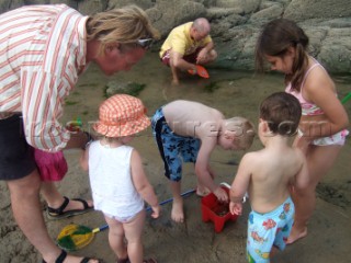 Children playing on a sandy beach looking for crustacea and crabs