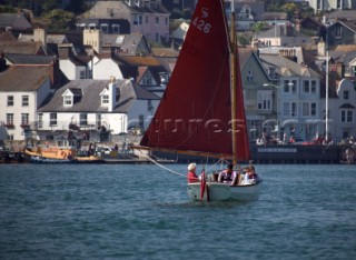 A Cornish Shrimper returns under brown sail to Dartmouth Harbour up the River Dart