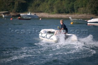 Young boy in a dinghy speeding in Salcombe Harbour