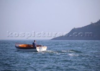 Lone fisherman on a fishing boat heads out to sea
