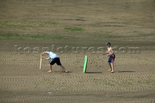 Boys playing cricket on beach at Salcombe, Devon