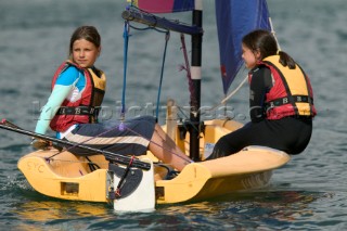 Two girls sailing small dinghy