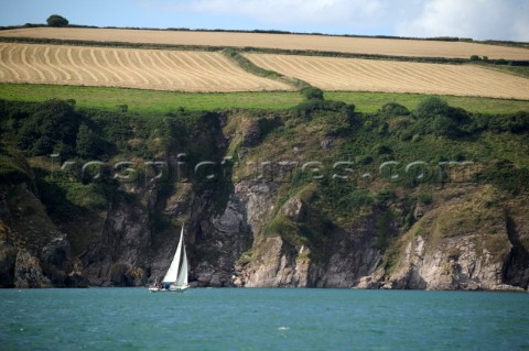 Cruising yacht sailing along the Devon coast