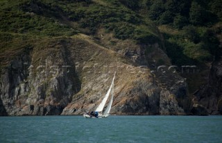 Cruising yacht sailing along the Devon coast