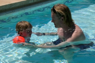 Man teaching little girl to swim in swimming pool