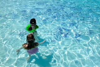 Two young children playing in swimming pool