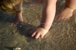 Little girl playing on beach in shallow water