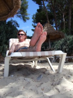 Man lying on sun lounger on sandy beach