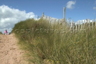 Little girl on path in sand dunes at Bantham, Devon